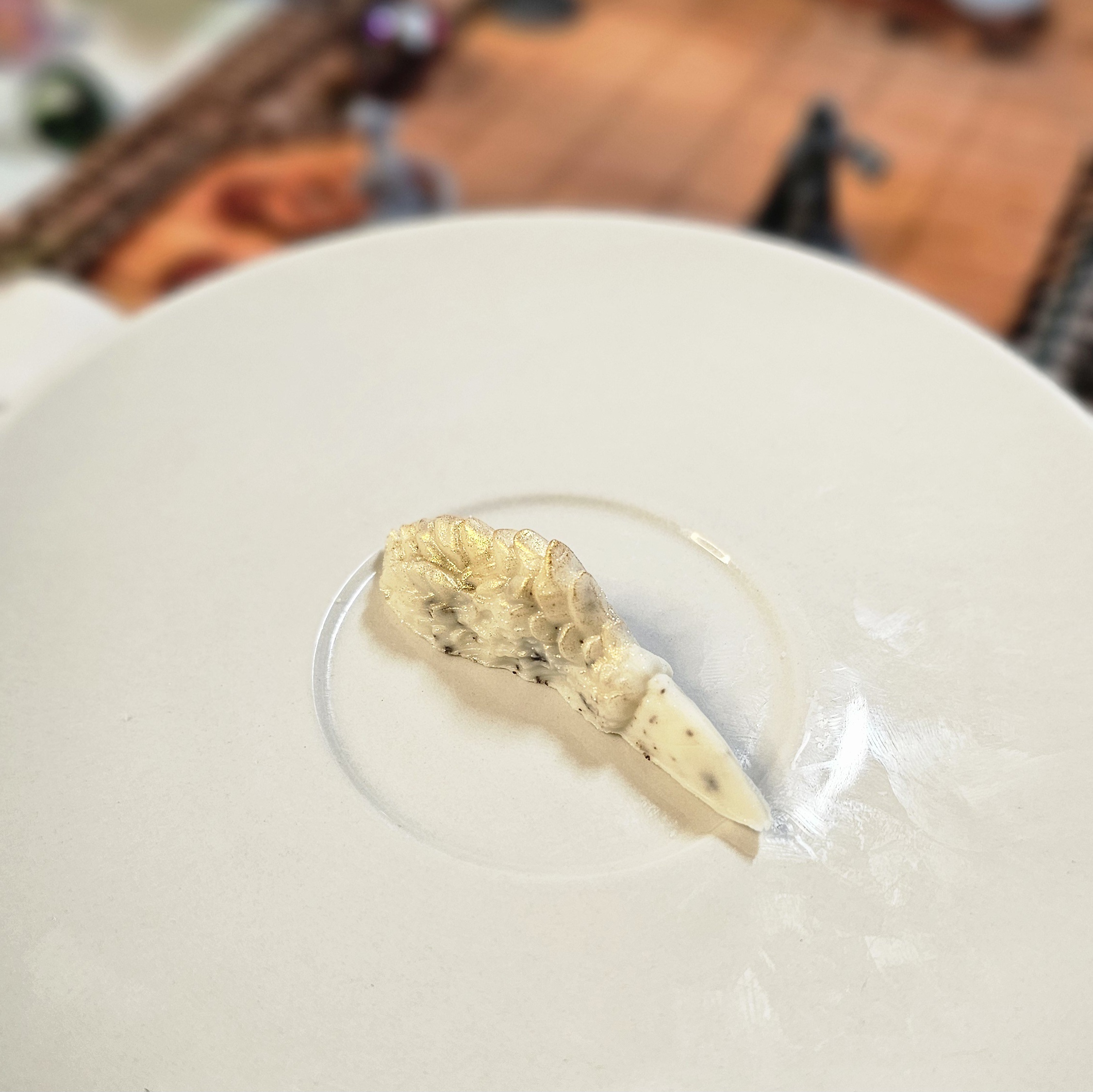 Cookies & Cream Dragon Finger Cookies and cream chocolate dragon finger displayed on a white plate with tabletop RPG miniatures, dice, and dungeon playmat blurred in the background.